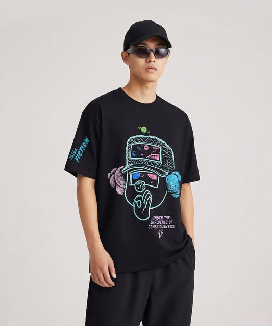 Person wearing a Tribe Fiction "Under the Influence" black t-shirt featuring a universal consciousness graphic design