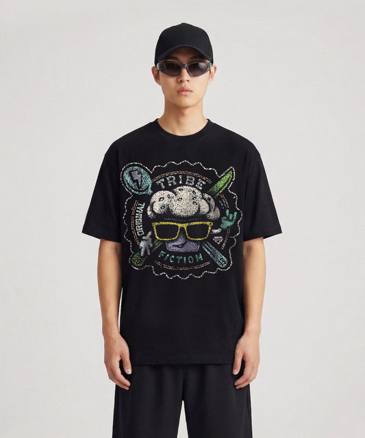 Person wearing a Tribe Fiction "Cupcakes" black t-shirt featuring a colorful cupcake graphic design