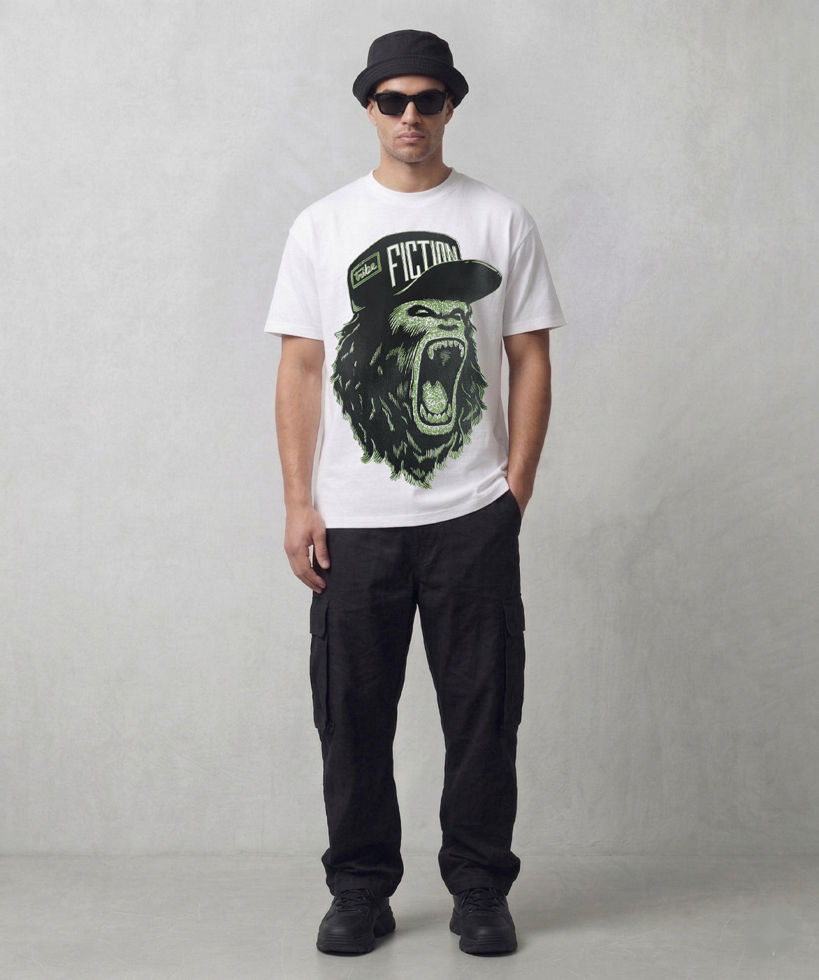 Person wearing a Tribe Fiction "Alpha Male" white t-shirt featuring a roaring gorilla graphic design
