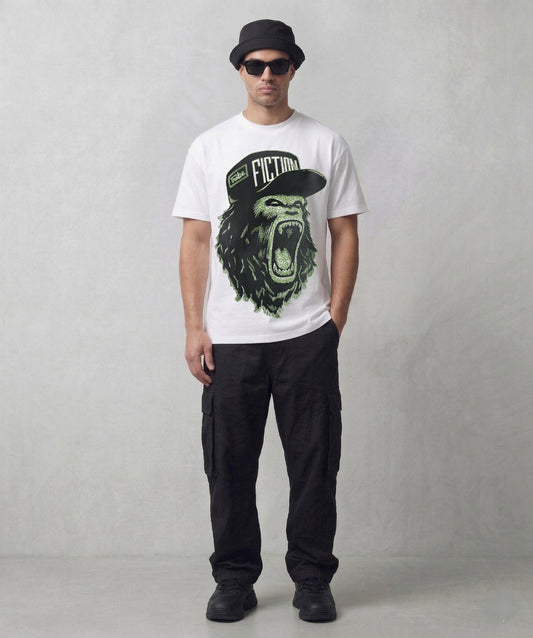 Person wearing a Tribe Fiction "Alpha Male" white t-shirt featuring a roaring gorilla graphic design